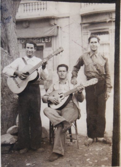 Grupo de soldados, tocando instrumentos musicales de cuerda, entre ellos Rodrigo Mejias Castillo [LT-SACERUELA-255] En: Fondo Fotográfico Los Legados de la Tierra ([1938])